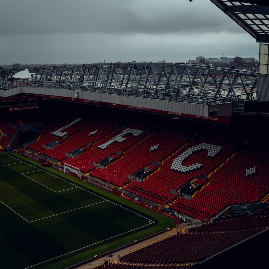 an empty stadium with red seats and a red and white sign